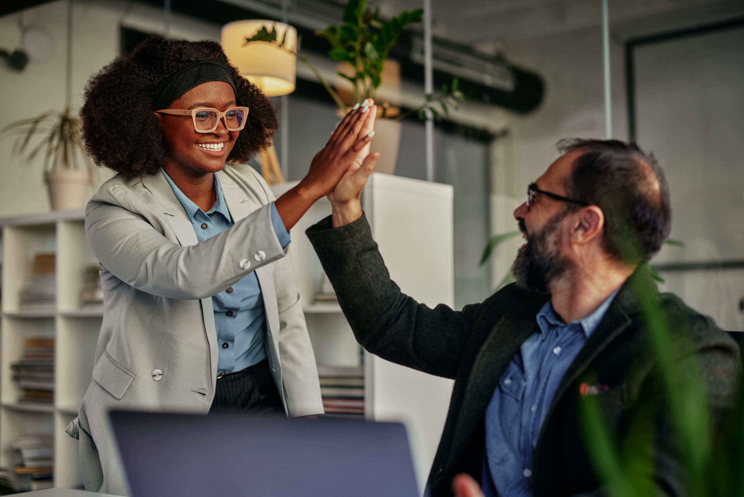 buyer and sales professional high-fiving in office